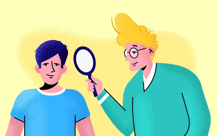 Two people where one is holding a magnifying glass up to the other.